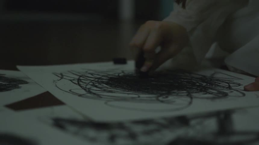 A woman that is drawing on paper with charcoal