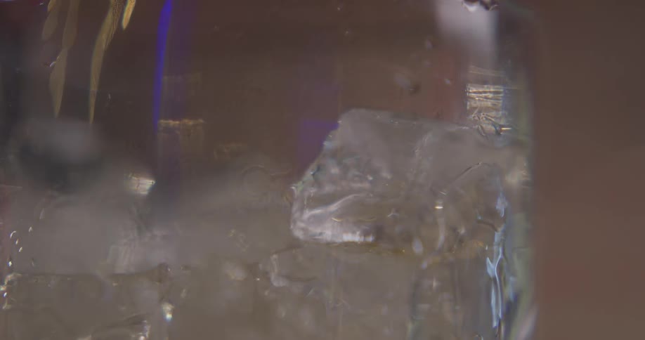 Liquid is being poured into a glass of ice