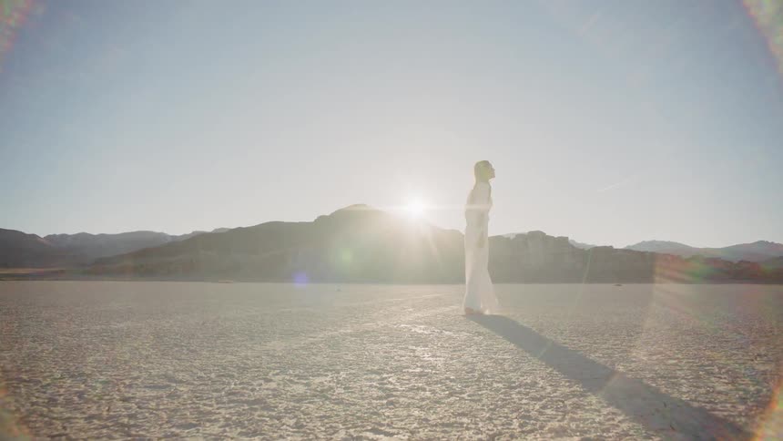 A woman in a white dress standing in a dried lake