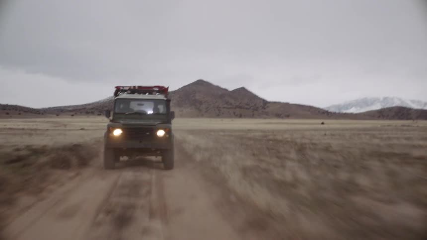People are driving a car on a dirt road