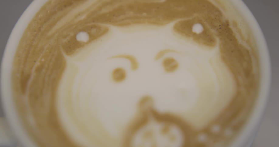 A face is created on top of a cup of coffee