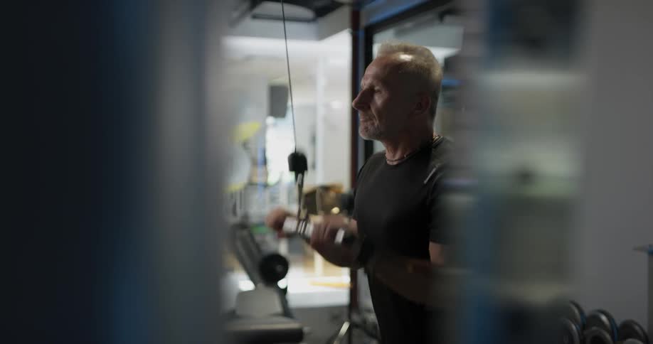 A man is working out on a machine in a gym