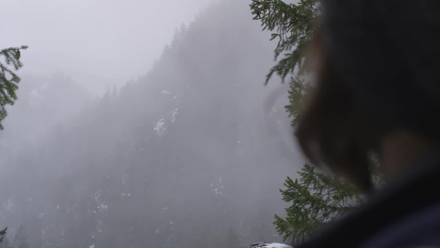 Person looks across foggy mountains and valley