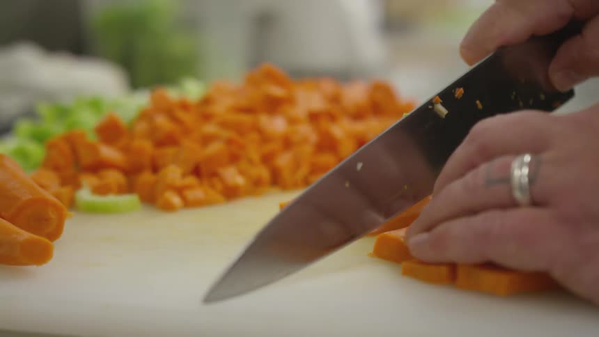 A person cutting carrots on a table