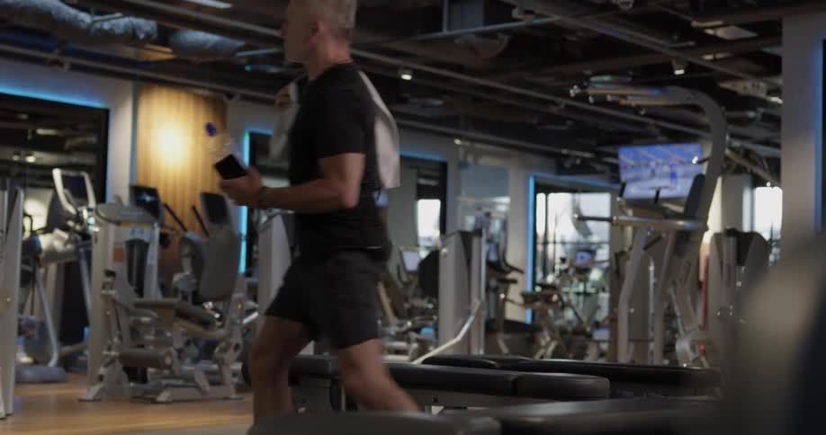 A man at the gym picks up his belongings and leaves