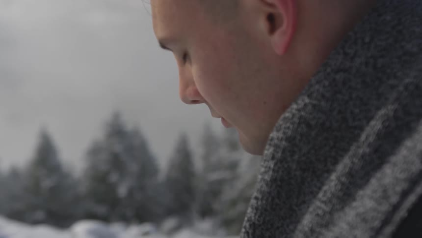 Man stands with eyes closed in a snowy landscape