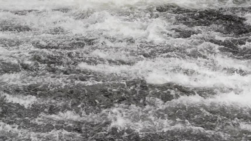 Fast flowing river runs through snowy forest