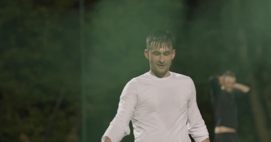 A man icing a soccer ball and hitting another man
