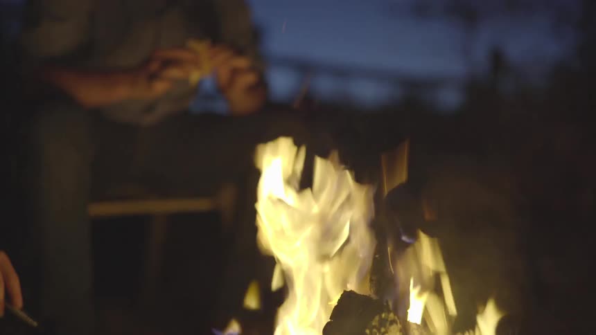 Two people are sitting in front of a fire