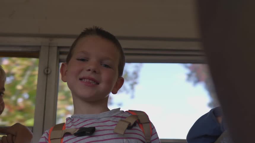 A child smiling on a moving bus