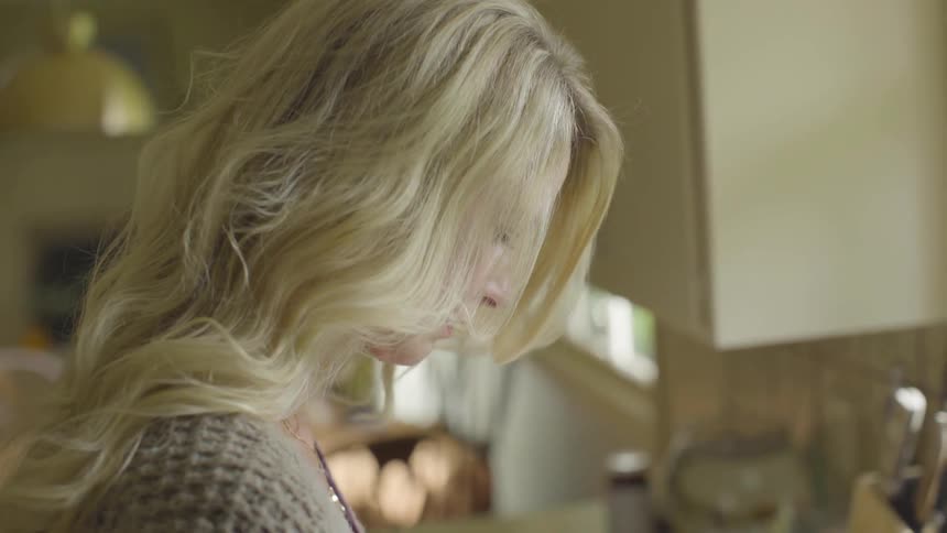 A woman is looking down indoors