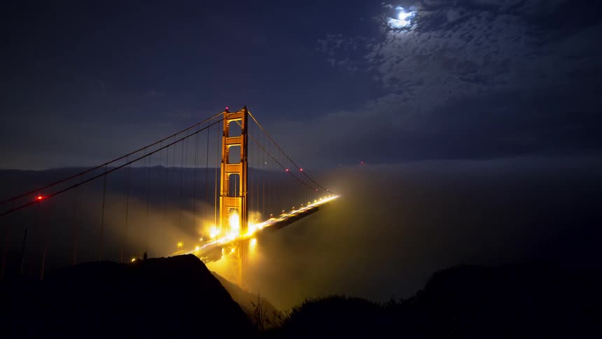 Vehicles driving across a bridge at night