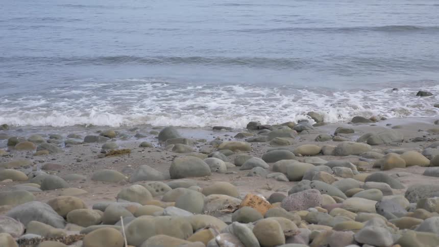 Small waves crash onto rocky beach