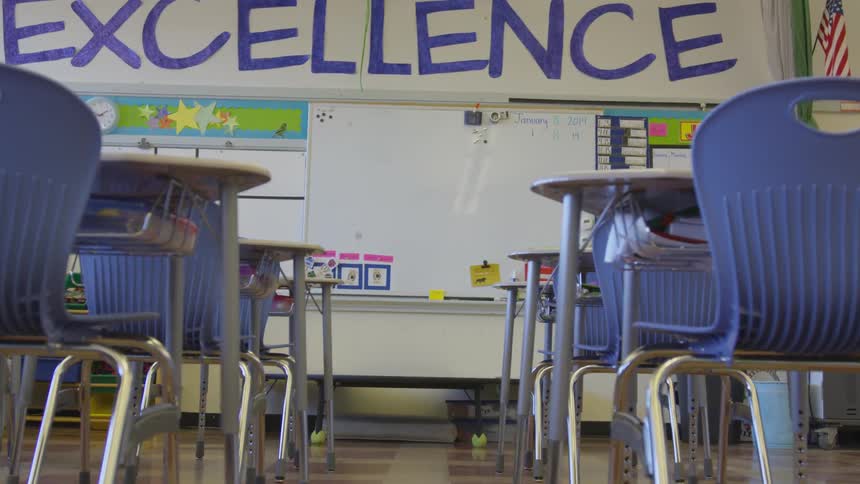 A classroom that has a whiteboard on the front wall