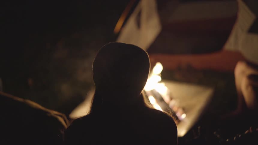 A group of people gather around a campfire