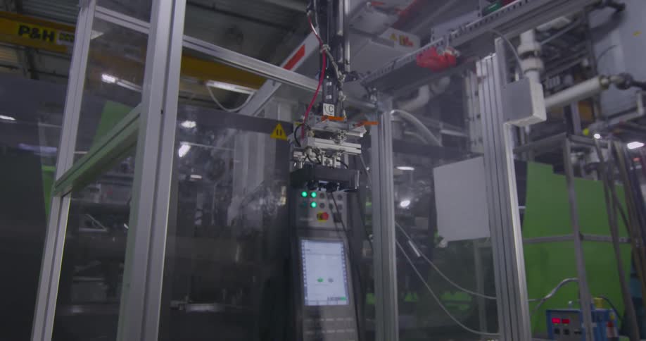 An automated robot drops an item on a moving assembly belt