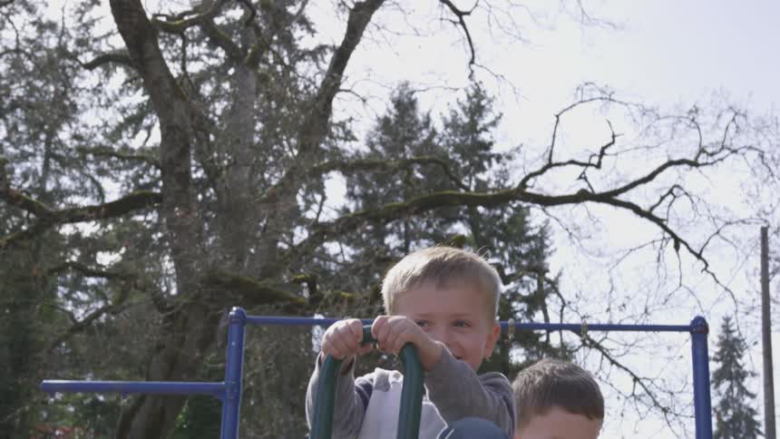 Two boys ride on seesaw during winter during the day