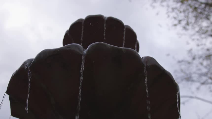 Water pours through stone fountain outdoors