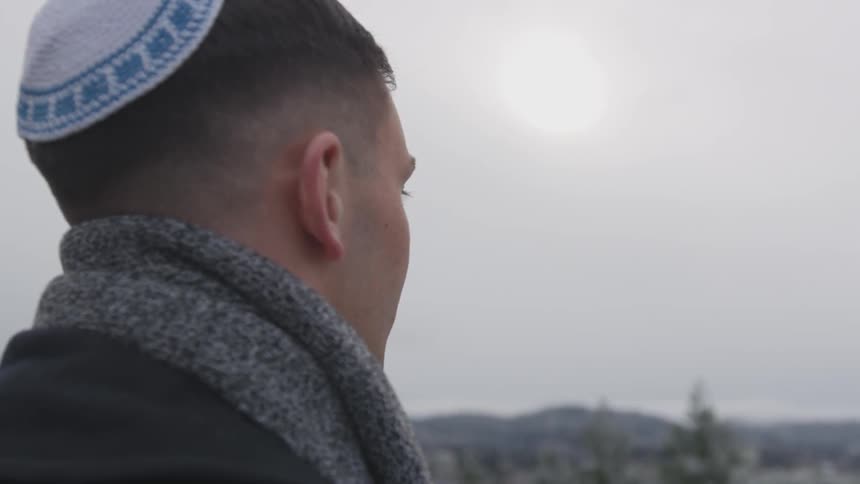 A jewish man wears a kippah outside