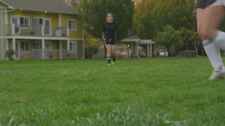 A girl throws a soccer ball to another girl