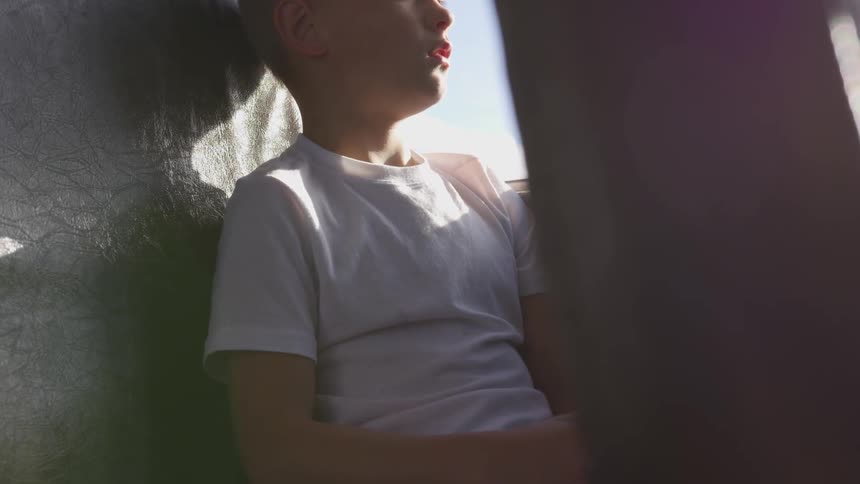 A young child sitting on a school bus