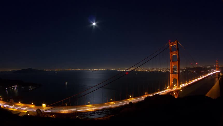 Cars are driving on the bridge at night