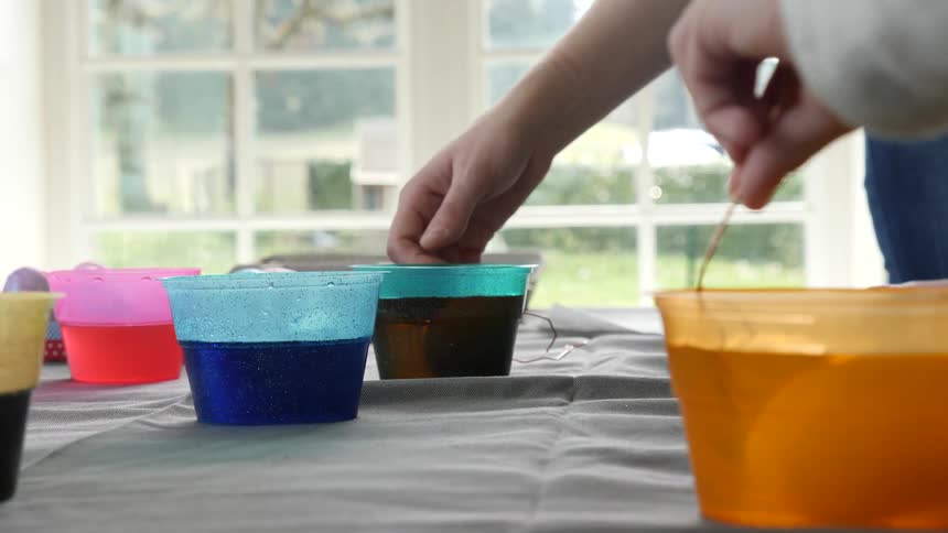 People are dyeing easter eggs at the table