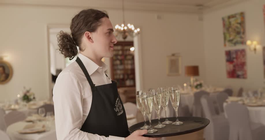 Waiter holds champagne glasses on a tray