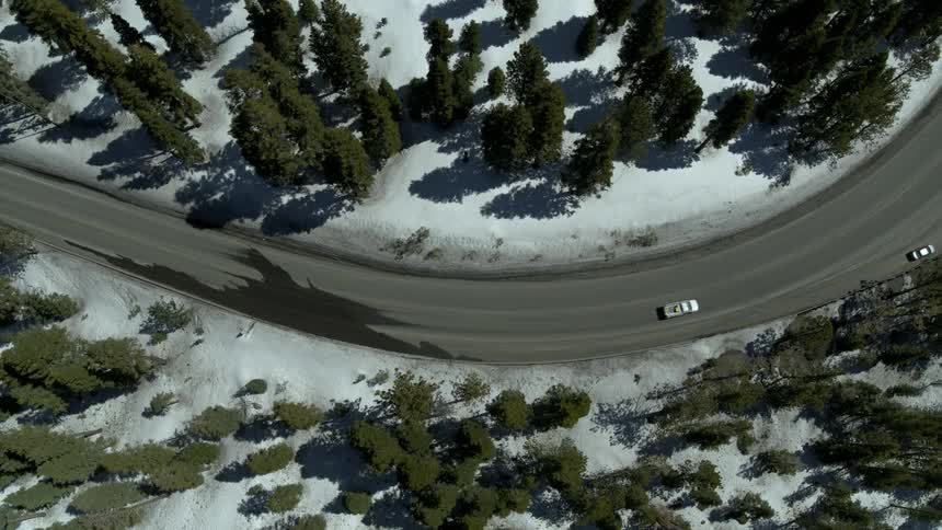 A car driving up a snowy mountain road