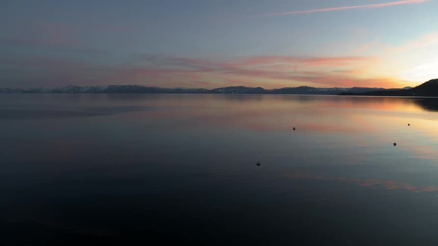 The sun is setting near the water