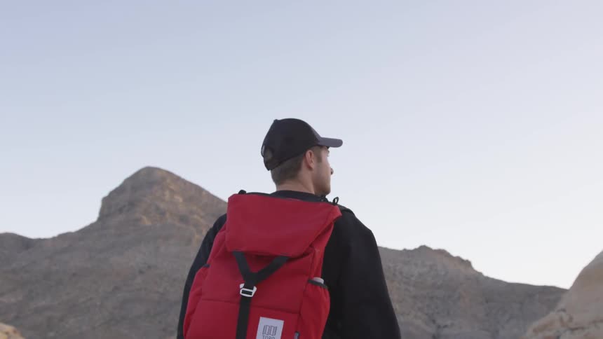 A man with a backpack hiking on a mountain