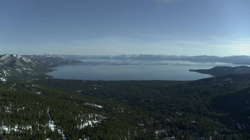 A large lake in the middle of a forest and mountain area