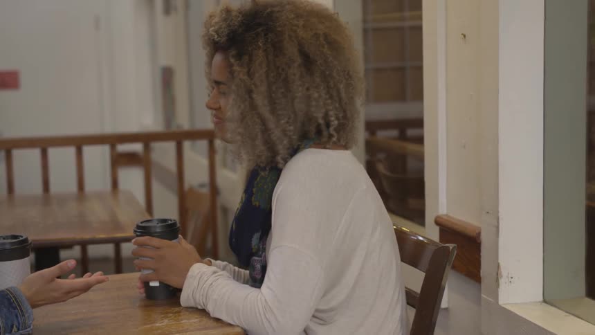 Woman with coffee smiles and nods