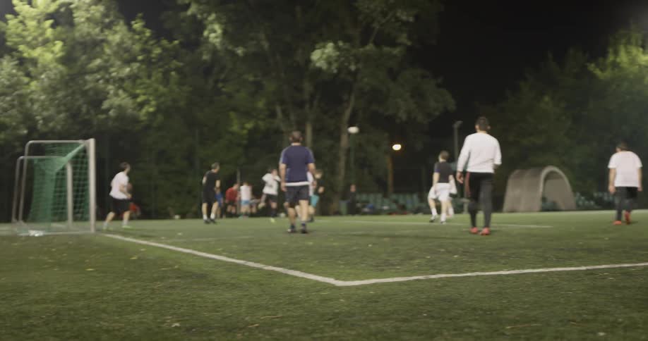 A guy kicking a soccer ball into a game