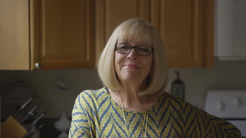 Elderly woman looks up and smiles into the camera