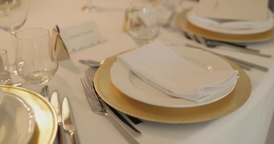 Formal dinnerware is on a table with name placards
