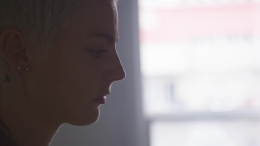 Woman sits in sunlit room studying something