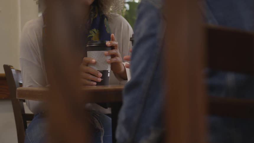 Two people have a conversation over coffee at table