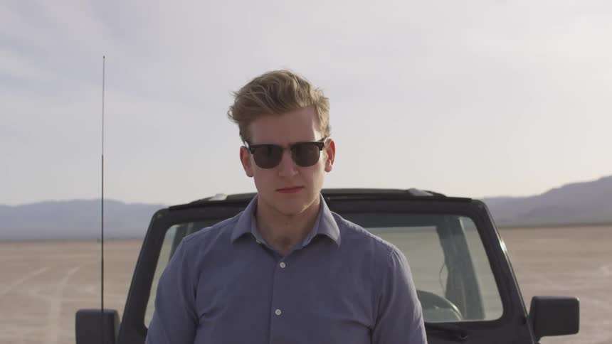 A man sitting on top of his car