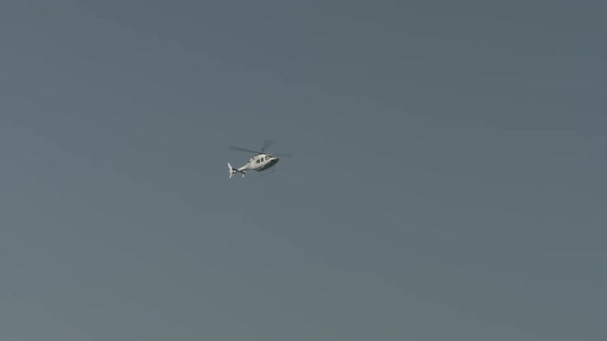 A white helicopter flies through the air
