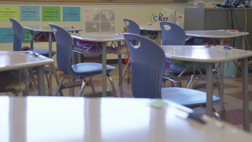 Empty blue chairs and desks in a classroom