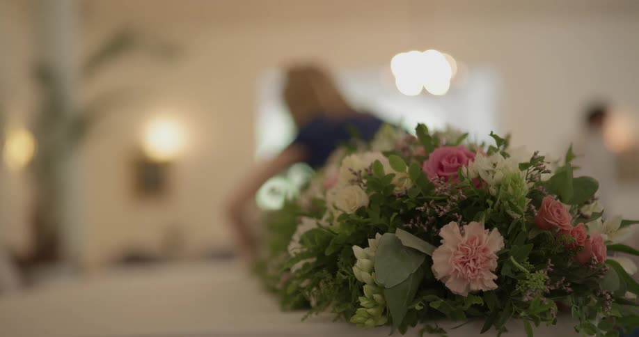 A person is putting flowers on a table