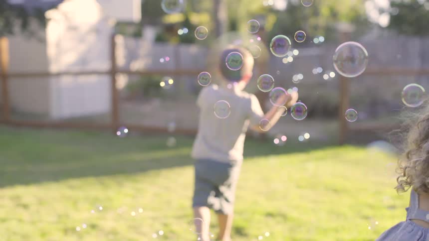 Children play with bubbles in the yard