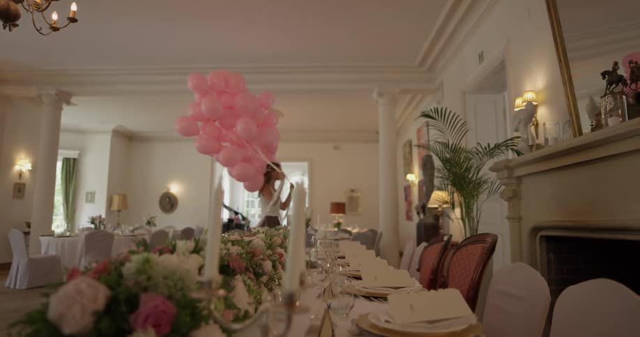 A woman brings balloons into a restaurant