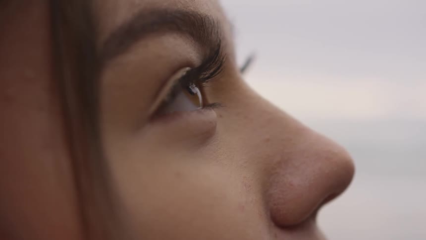 A woman blinks her eyes outside