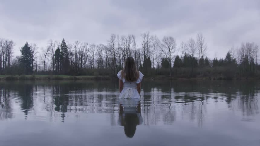 A woman is waist deep in the water