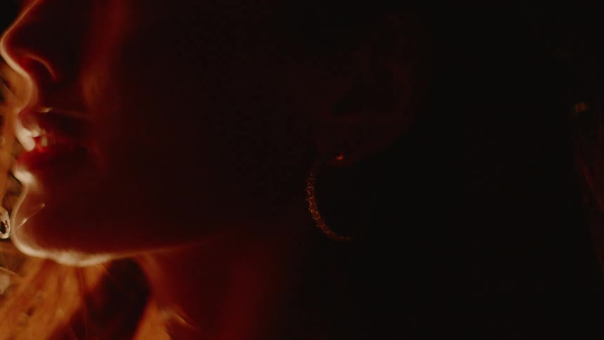 A man standing in front of a fire runs his hair through a woman's hair