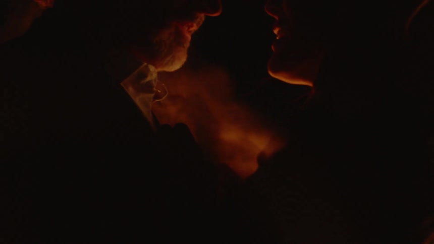 Man and woman dancing in front of a blowing fire
