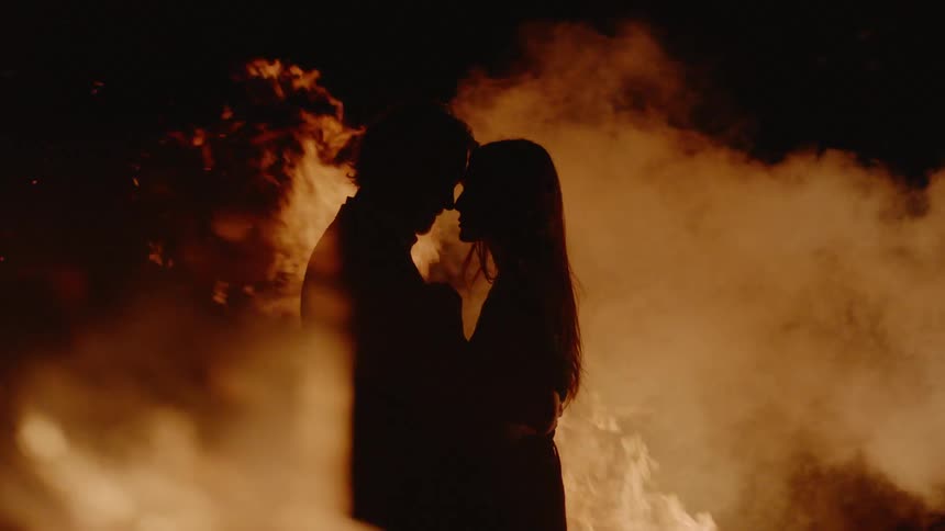 A man and woman are by a fire