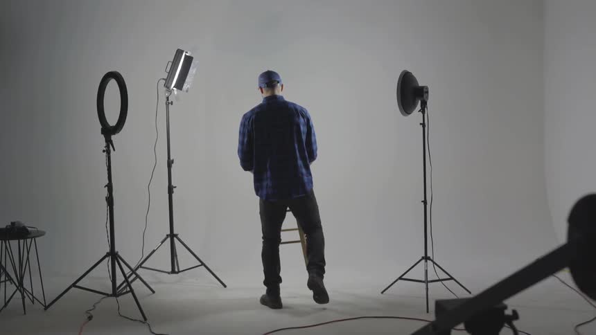 Man places stool at center of photography set